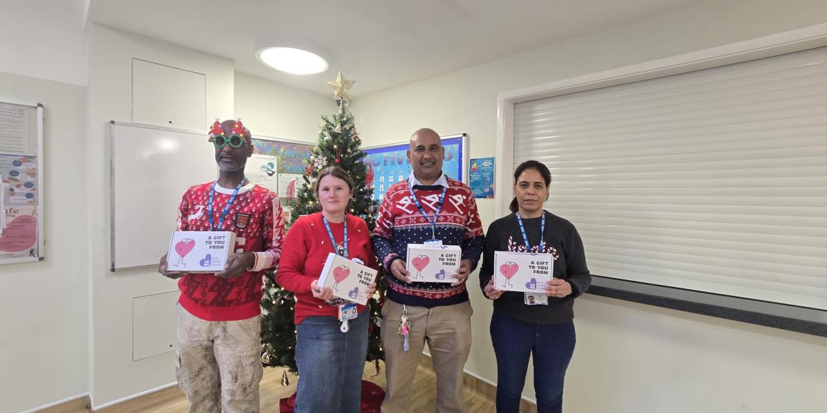 CNWL staff at Rosedale Court with holding their wellbeing boxes in front of a Christmas tree on Christmas Day