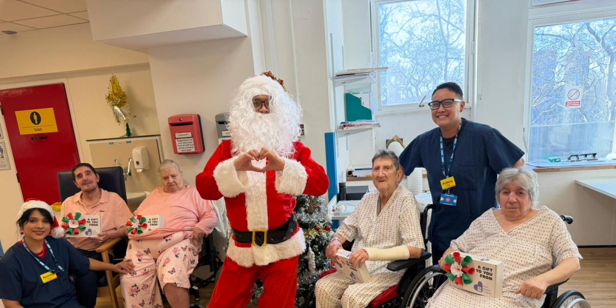 Patients at St Pancras Hospital and Santa Claus with wellbeing boxes on Christmas Day
