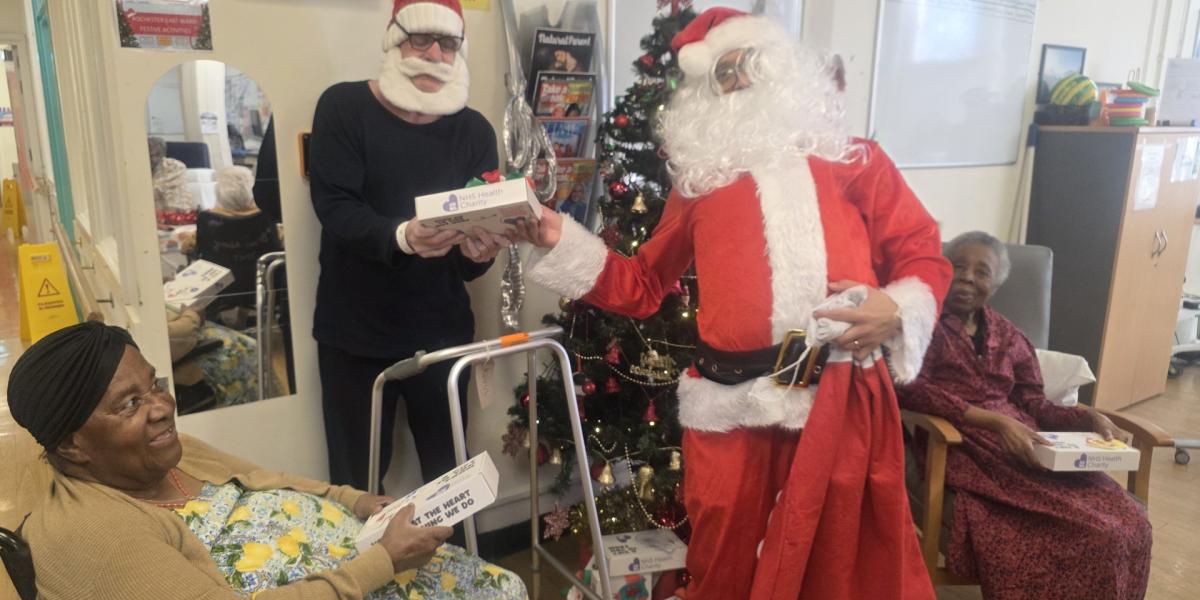 Santa giving CNWL patients at St Pancras Hospital their wellbeing boxes on Christmas Day