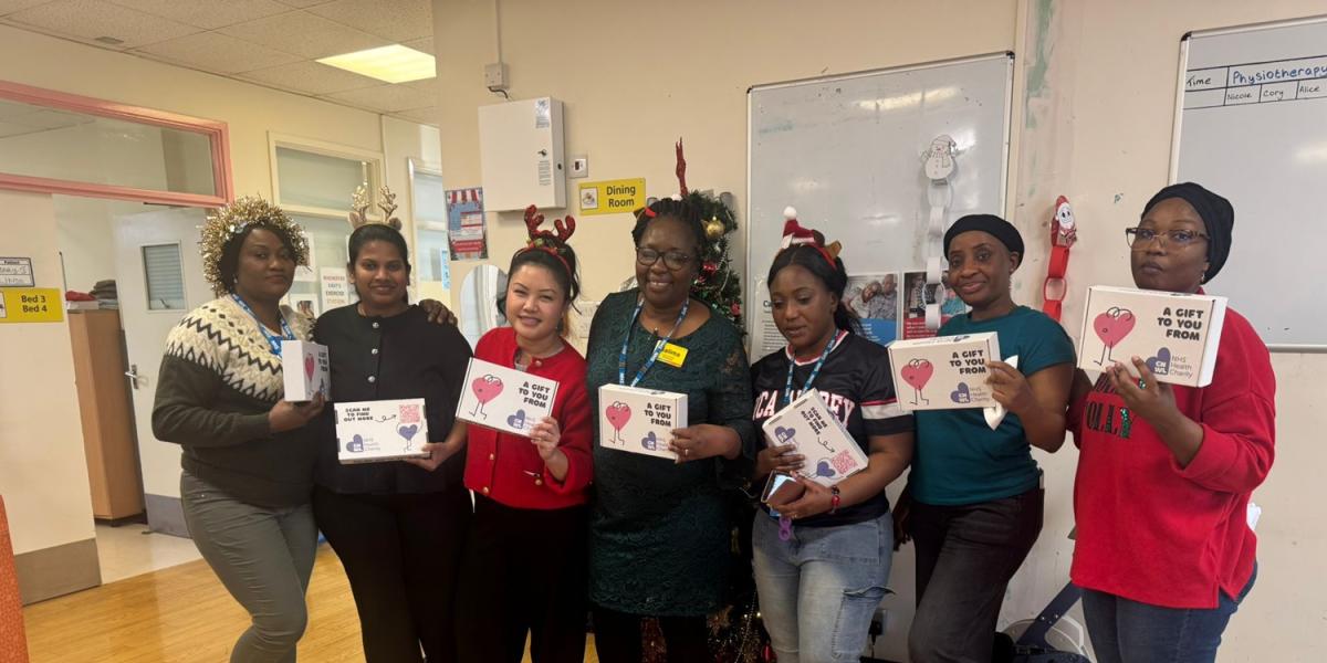 CNWL staff at St Pancras Hospital standing and smiling with their wellbeing boxes on Christmas Day