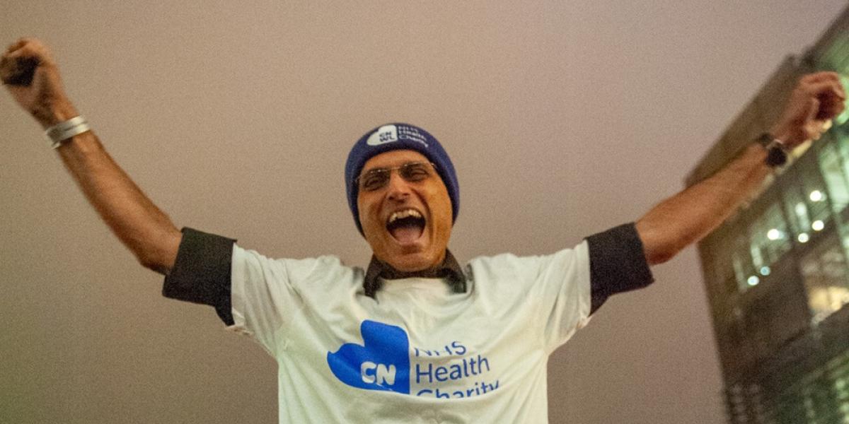 Kiran with his hands in the air celebrating walking across hot coals