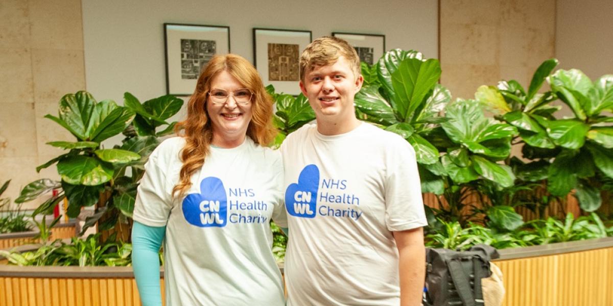 Melanie and Oscar standing and wearing CNWL NHS Health Charity t-shirts