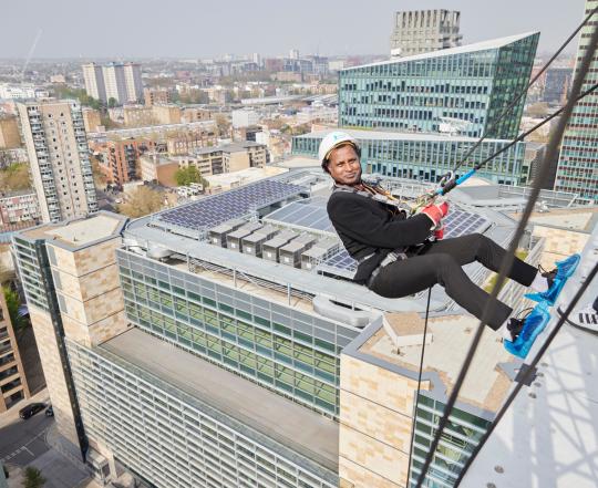 Man Abseiling Down Building At British Land