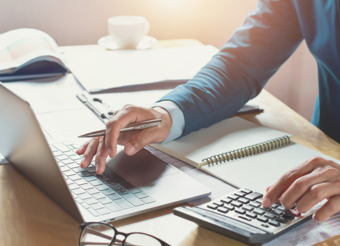 A man doing finance work on a laptop