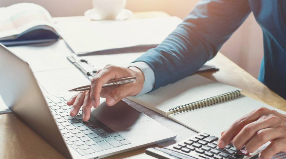 A man doing finance work on a laptop
