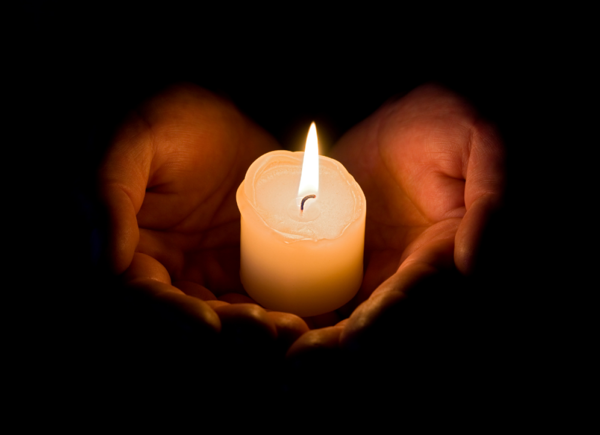 A candle held in a person's hands