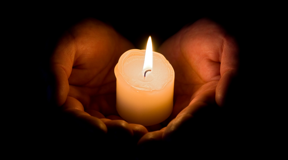 A candle held in a person's hands